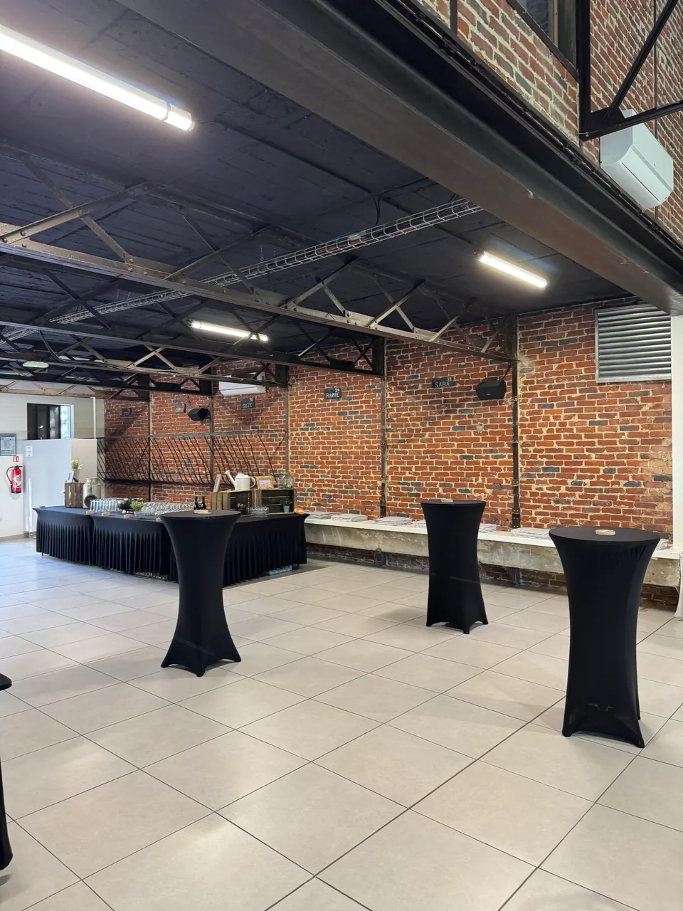 Mange-debout noirs installés dans une salle événementielle