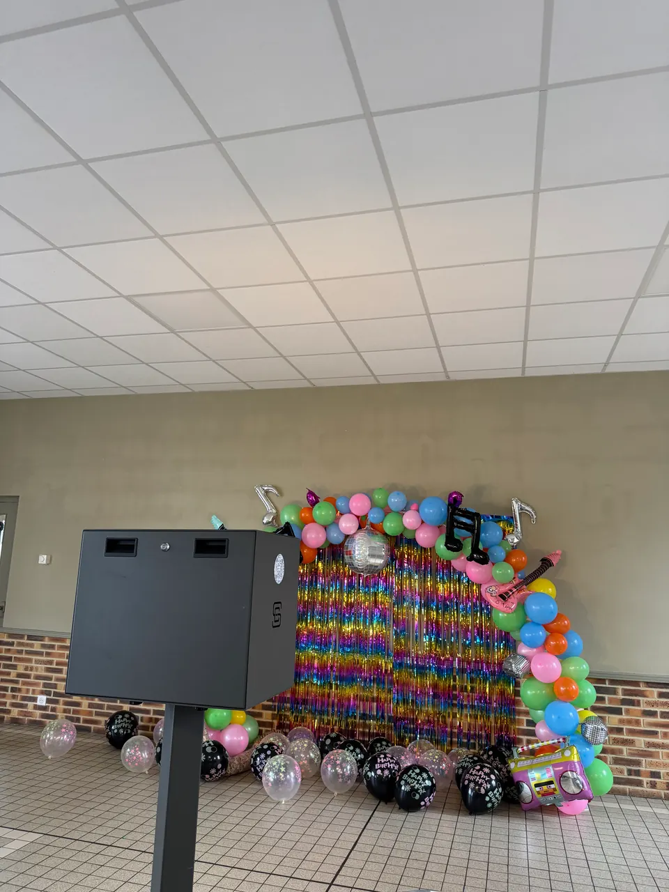 Photobooth installé devant une décoration colorée pour un anniversaire
